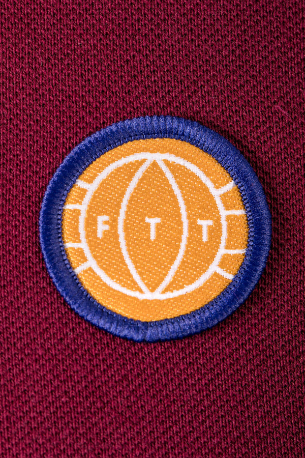Close-up of a patch with 'FTT' on a maroon background