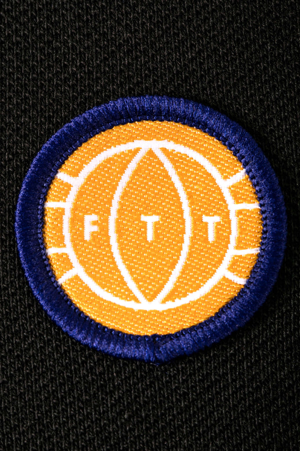 Circular patch with 'FT' logo on a black background