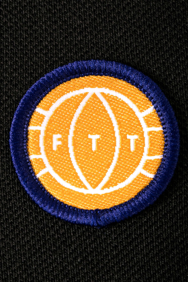 Circular patch with 'FT' logo on a black background