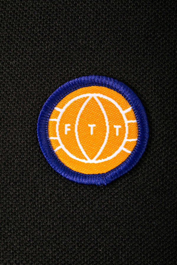 Circular patch with 'FITT' logo on a black background