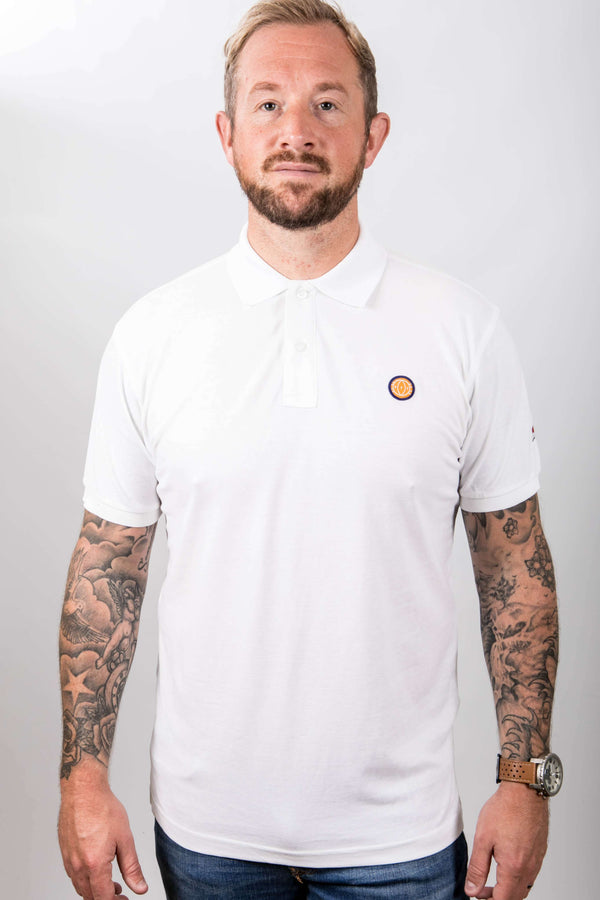 Man wearing a white t-shirt with a small logo on a plain background