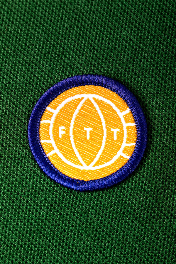 Embroidered logo on a green fabric background