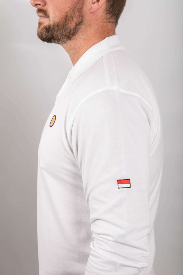 White long-sleeve shirt with small logos on a gray background