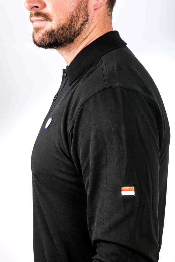 Man wearing a black long-sleeve shirt with a small logo on the chest against a white background