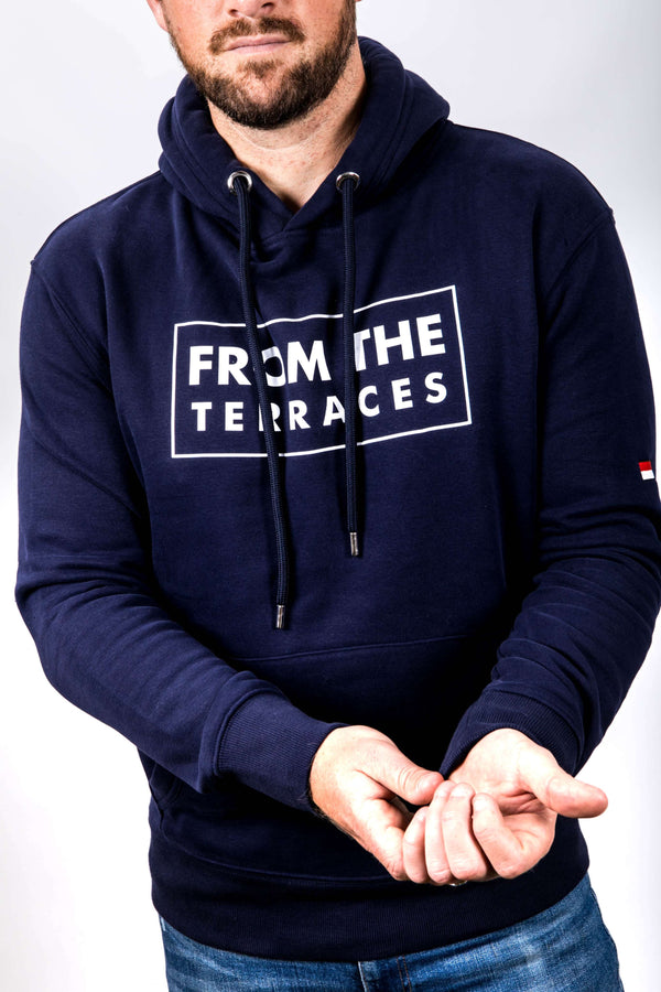 Person wearing a navy hoodie with 'From the Terraces' text on a white background
