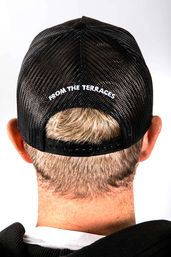 Black cap with 'From the Terraces' text worn by a person on a white background
