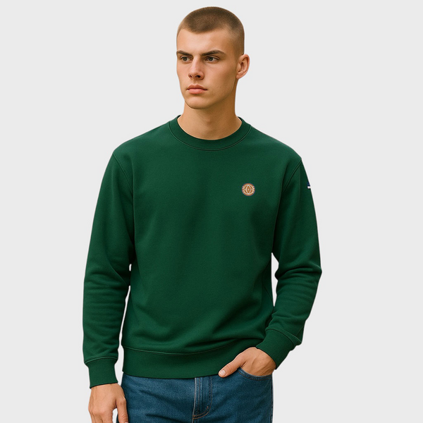 Man wearing a green sweatshirt with a small logo on a light gray background