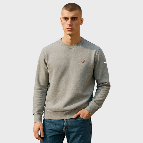 Man wearing a gray sweatshirt with a small logo on a light gray background