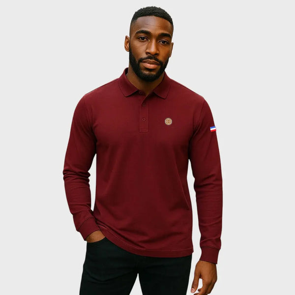 Man wearing a maroon long-sleeve polo shirt with a small logo on a light gray background